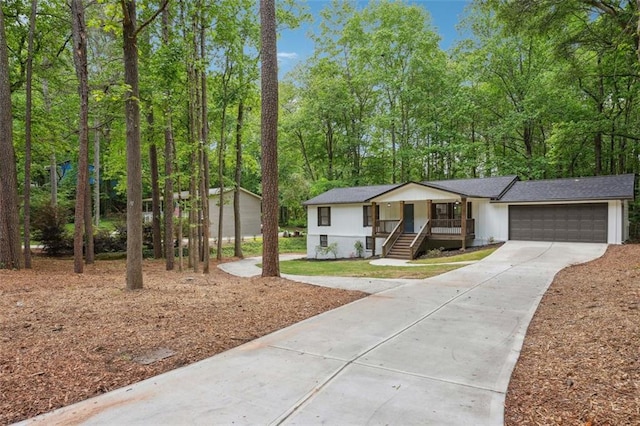 ranch-style home with driveway, an attached garage, and covered porch