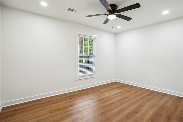 empty room with wood finished floors, recessed lighting, and baseboards