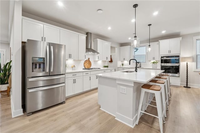 2445 Hidden Creek Rd, Kennesaw, GA 30152 - kitchen featuring appliances with stainless steel finishes, a sink, wall chimney range hood, white cabinetry, and recessed lighting