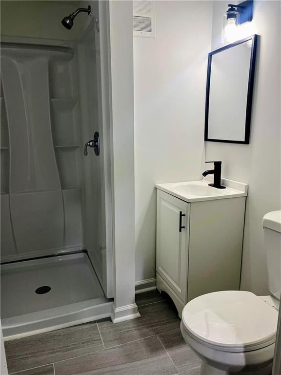 bathroom with vanity, toilet, and a shower