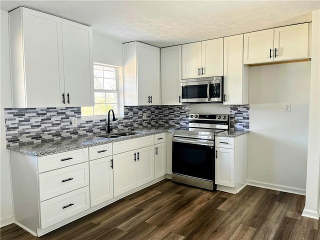 kitchen featuring stainless steel appliances, white cabinetry, and sink