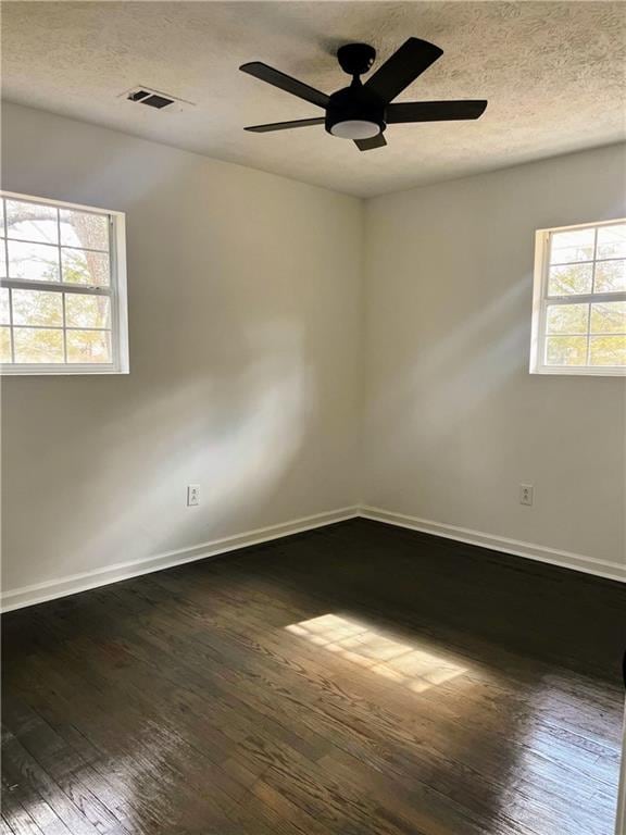 spare room with a textured ceiling, dark hardwood / wood-style floors, and ceiling fan