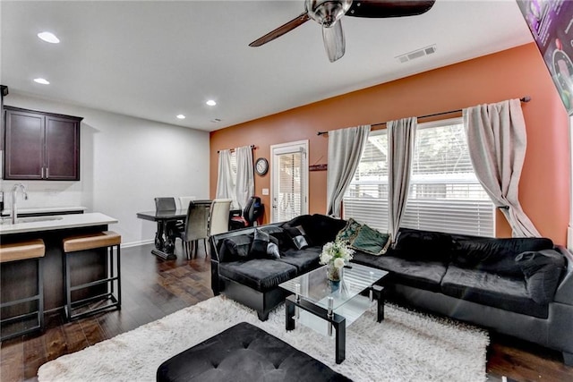 living room featuring a ceiling fan, dark wood finished floors, visible vents, and recessed lighting