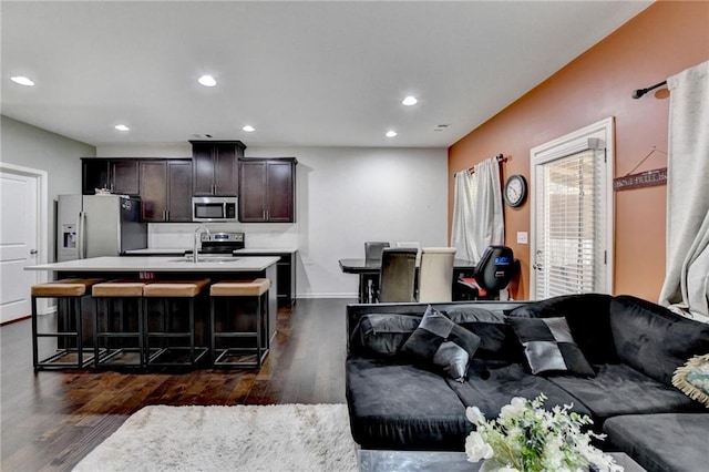 living room featuring dark wood-style floors, recessed lighting, and baseboards