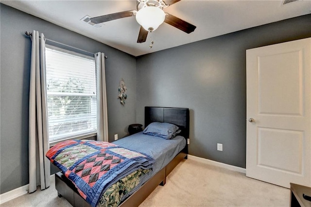 bedroom with light carpet, visible vents, baseboards, and ceiling fan