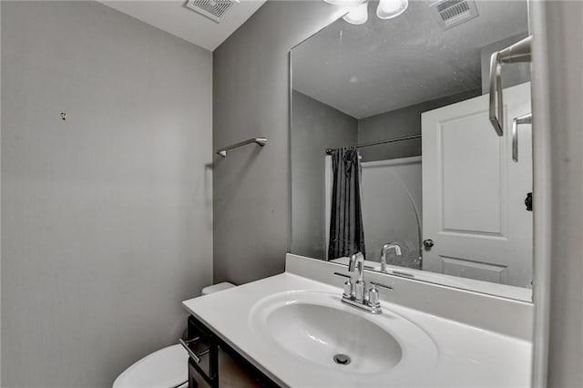 bathroom with curtained shower, visible vents, vanity, and toilet