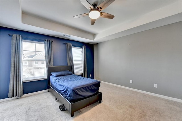 bedroom with baseboards and a tray ceiling