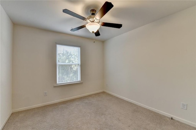 unfurnished room featuring light colored carpet, ceiling fan, and baseboards