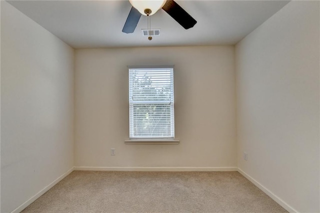 unfurnished room with a ceiling fan, light carpet, visible vents, and baseboards