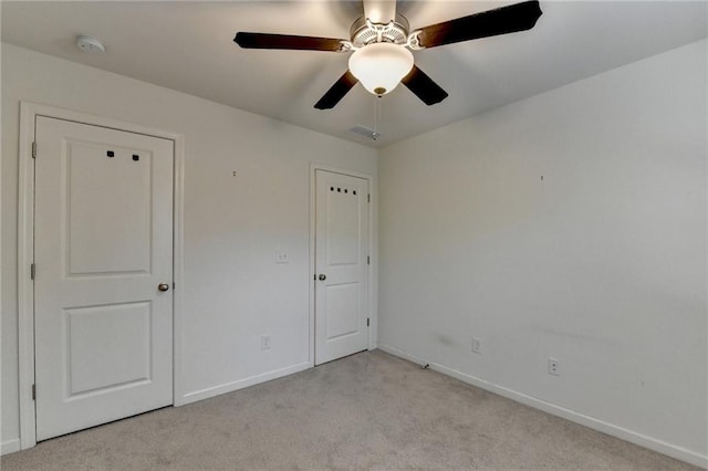 unfurnished bedroom featuring baseboards, visible vents, and light colored carpet