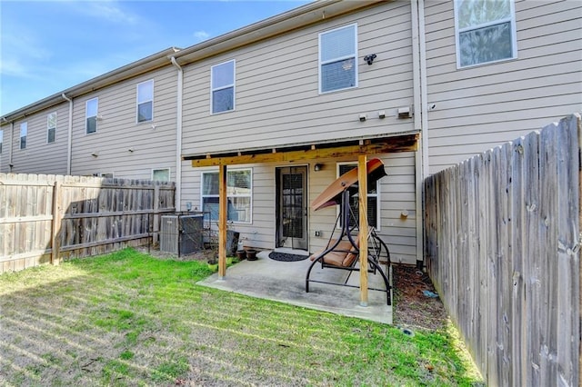 back of property featuring a fenced backyard, a patio, and a lawn