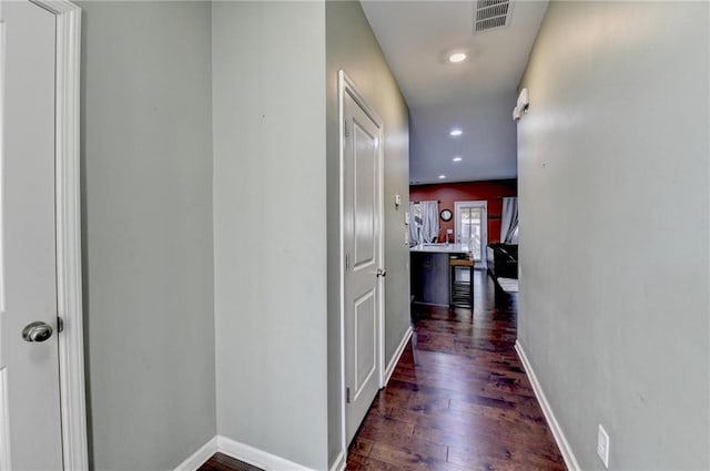 corridor featuring baseboards, visible vents, dark wood finished floors, and recessed lighting