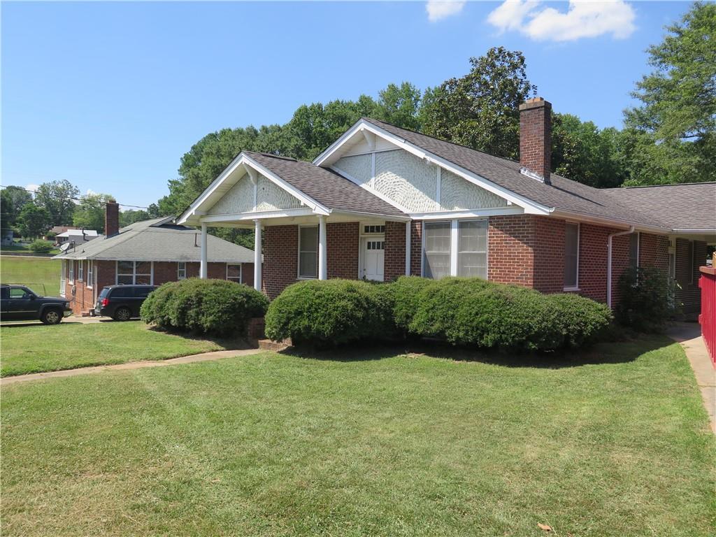 1 K Ave, Gainesville, GA 30504 - view of front of property featuring brick siding, a chimney, a front lawn, and roof with shingles