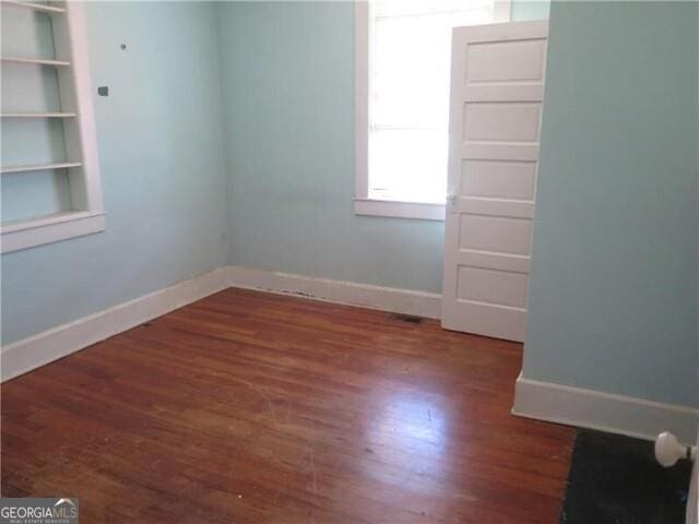 empty room with dark wood-type flooring