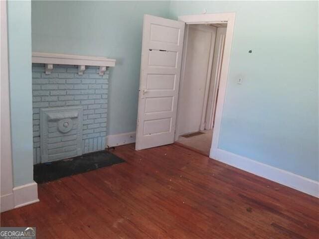 unfurnished room with dark wood-type flooring