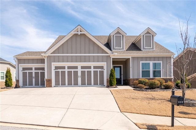 craftsman-style house featuring a garage, roof with shingles, board and batten siding, and concrete driveway