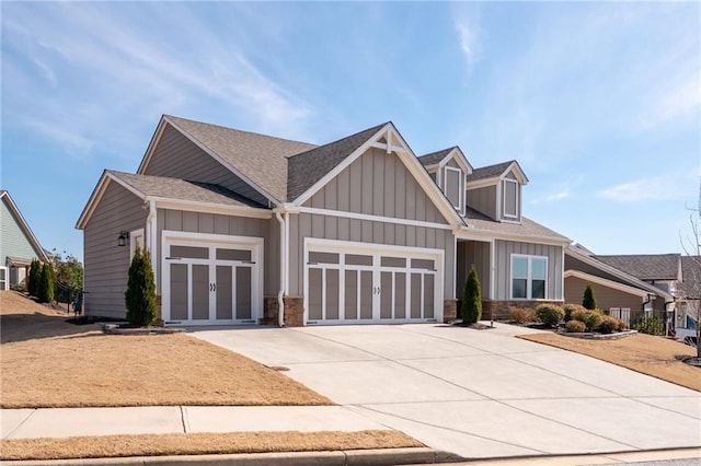 craftsman-style home featuring a garage, concrete driveway, board and batten siding, and roof with shingles