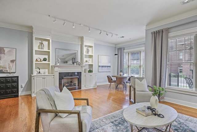 273 12th St NE Unit 421, Atlanta, GA 30309 - living room featuring track lighting, light wood-type flooring, a fireplace, and baseboards