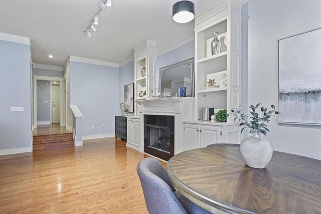 273 12th St NE Unit 421, Atlanta, GA 30309 - dining room with track lighting, light wood-style floors, baseboards, and a fireplace