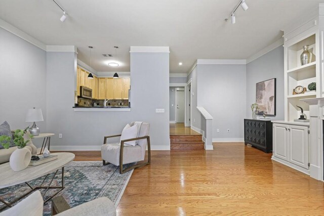 273 12th St NE Unit 421, Atlanta, GA 30309 - living area featuring rail lighting, ornamental molding, visible vents, light wood finished floors, and baseboards