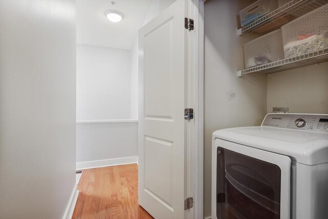 273 12th St NE Unit 421, Atlanta, GA 30309 - washroom with laundry area, baseboards, light wood-type flooring, and washer / dryer