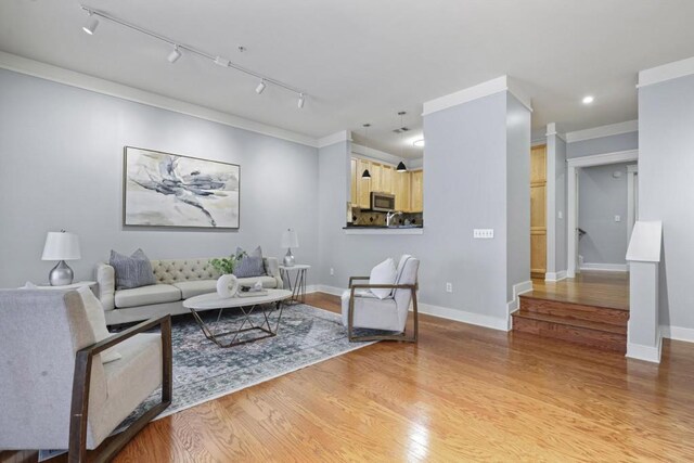 273 12th St NE Unit 421, Atlanta, GA 30309 - living room featuring baseboards, ornamental molding, light wood finished floors, and track lighting