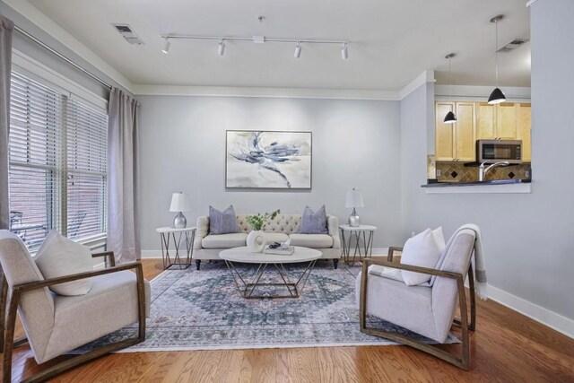 273 12th St NE Unit 421, Atlanta, GA 30309 - living area featuring rail lighting, baseboards, visible vents, and wood finished floors