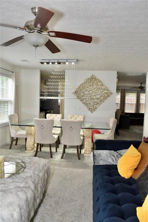 1218 Matt Moore Ct, Lithia Springs, GA 30122 - carpeted living area with a textured ceiling, ceiling fan, visible vents, and a wealth of natural light