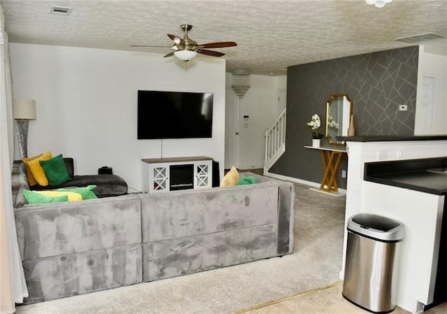 1218 Matt Moore Ct, Lithia Springs, GA 30122 - living room featuring stairway, a ceiling fan, a textured ceiling, and visible vents