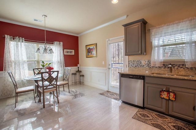 kitchen featuring sink, crown molding, dishwasher, pendant lighting, and light stone countertops