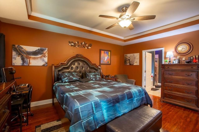 bedroom featuring a raised ceiling, crown molding, and dark hardwood / wood-style flooring