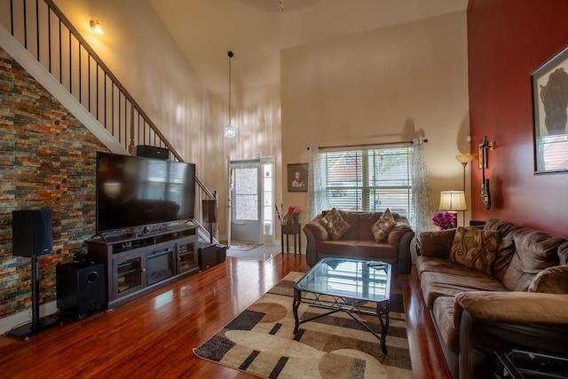 living room with hardwood / wood-style flooring and high vaulted ceiling