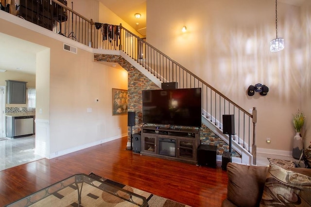 living room featuring dark wood-type flooring and a towering ceiling