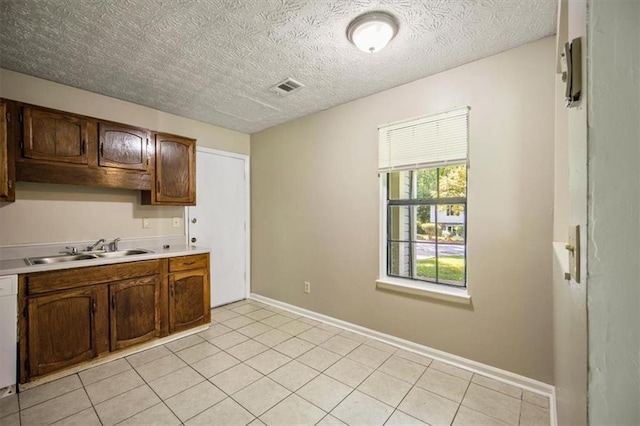 5426 Martins Crossing Rd, Stone Mountain, GA 30088 - kitchen featuring light countertops, dishwasher, a textured ceiling, and light tile patterned floors