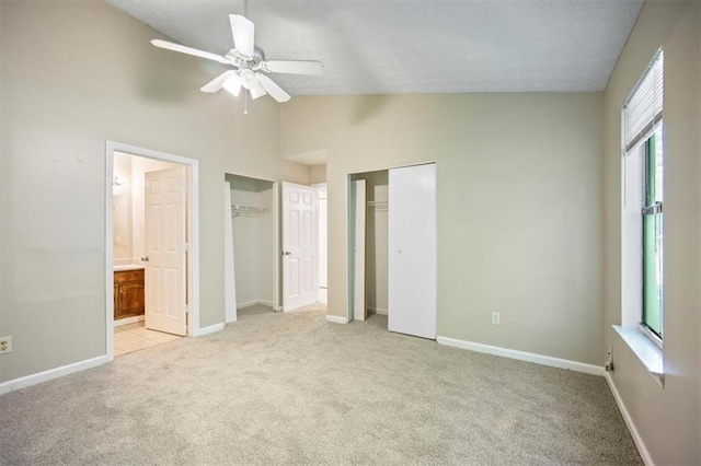 5426 Martins Crossing Rd, Stone Mountain, GA 30088 - unfurnished bedroom with light carpet, multiple windows, two closets, ensuite bathroom, and vaulted ceiling