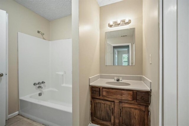 5426 Martins Crossing Rd, Stone Mountain, GA 30088 - full bathroom featuring tub / shower combination, vanity, a textured ceiling, and tile patterned flooring