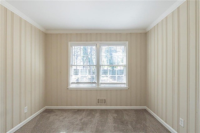 carpeted spare room featuring crown molding