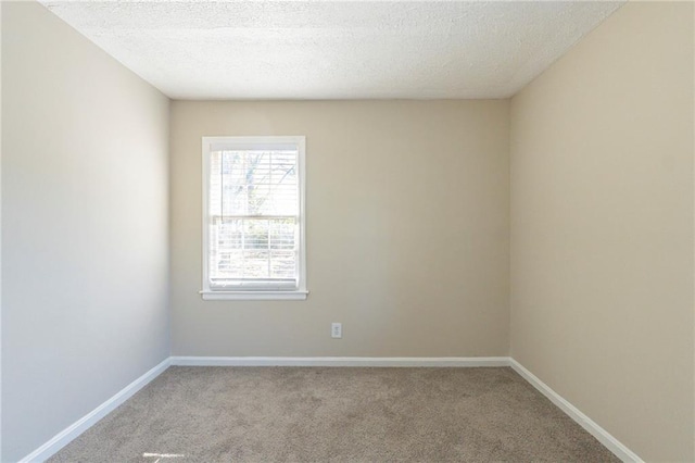 empty room with light carpet and a textured ceiling