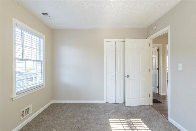 unfurnished bedroom featuring carpet floors and a closet