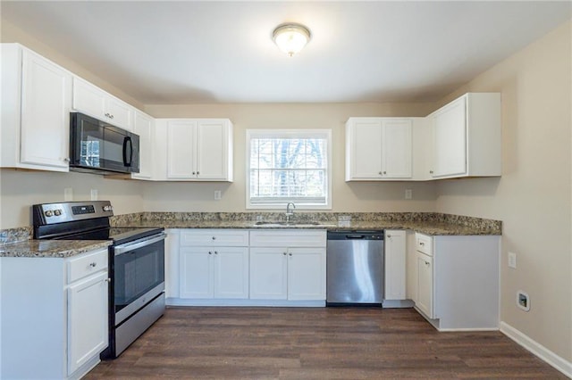 kitchen with dark stone counters, sink, appliances with stainless steel finishes, dark hardwood / wood-style flooring, and white cabinetry