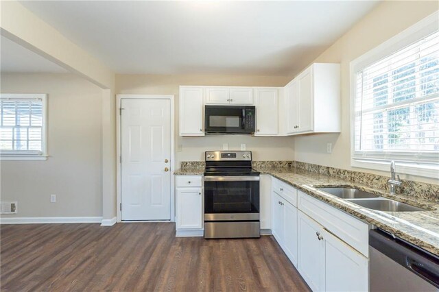 kitchen with sink, dark wood-type flooring, light stone counters, white cabinets, and appliances with stainless steel finishes