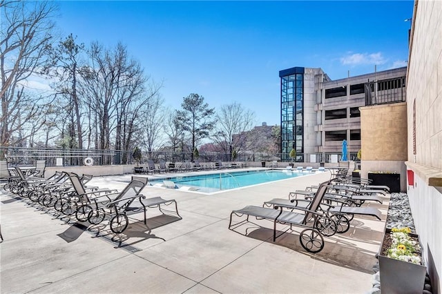 pool with a patio area and fence