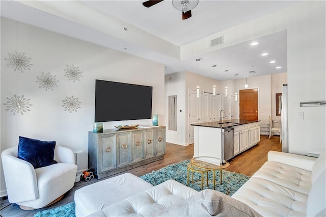 living room with a ceiling fan, wood finished floors, visible vents, and recessed lighting