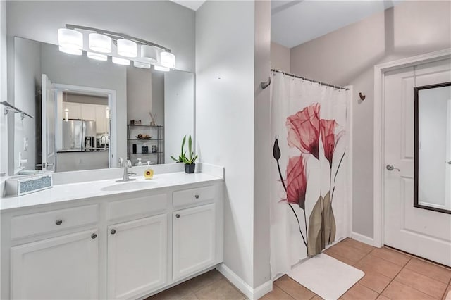 full bathroom with curtained shower, vanity, baseboards, and tile patterned floors