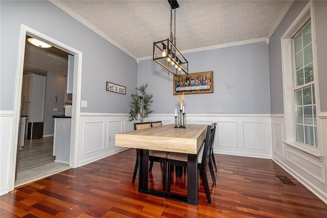 8601 Flint Hill Rd, Douglasville, GA 30135 - dining area with a textured ceiling, dark wood-style floors, a decorative wall, ornamental molding, and a chandelier