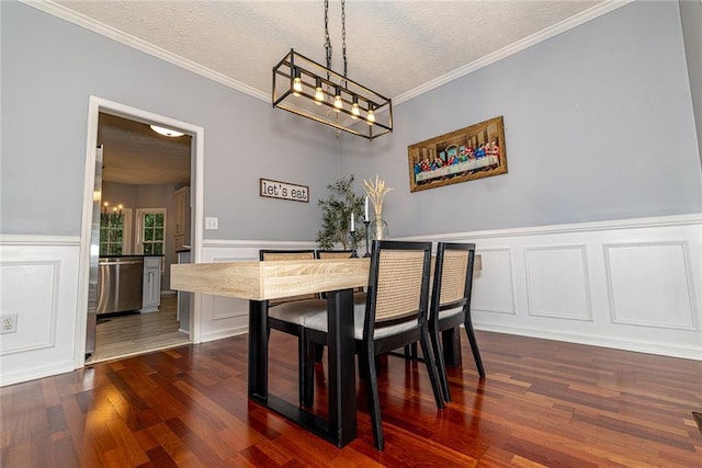 8601 Flint Hill Rd, Douglasville, GA 30135 - dining room with a chandelier, dark wood-type flooring, a textured ceiling, ornamental molding, and a decorative wall
