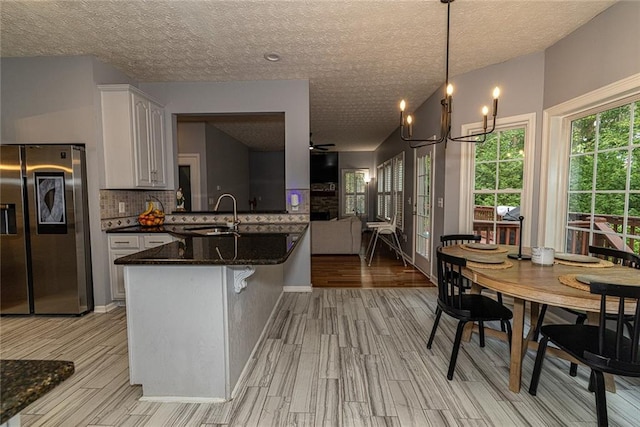 8601 Flint Hill Rd, Douglasville, GA 30135 - kitchen with stainless steel refrigerator with ice dispenser, a sink, decorative backsplash, light wood-style flooring, and a textured ceiling
