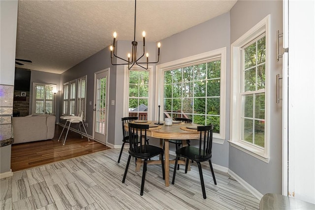 8601 Flint Hill Rd, Douglasville, GA 30135 - dining area featuring a chandelier, a textured ceiling, light wood-type flooring, and baseboards