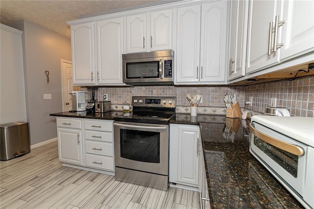8601 Flint Hill Rd, Douglasville, GA 30135 - kitchen with stainless steel appliances, white cabinetry, backsplash, dark stone countertops, and a textured ceiling