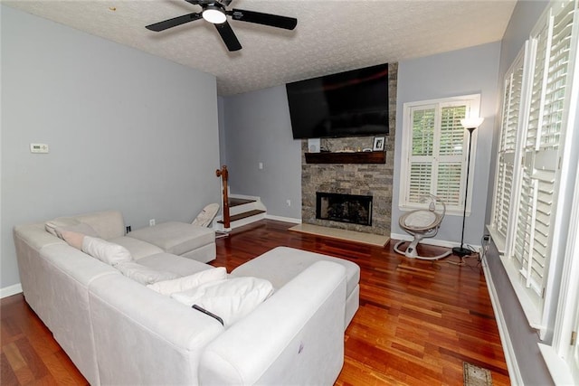 8601 Flint Hill Rd, Douglasville, GA 30135 - living room featuring ceiling fan, wood finished floors, a fireplace, a textured ceiling, and stairs